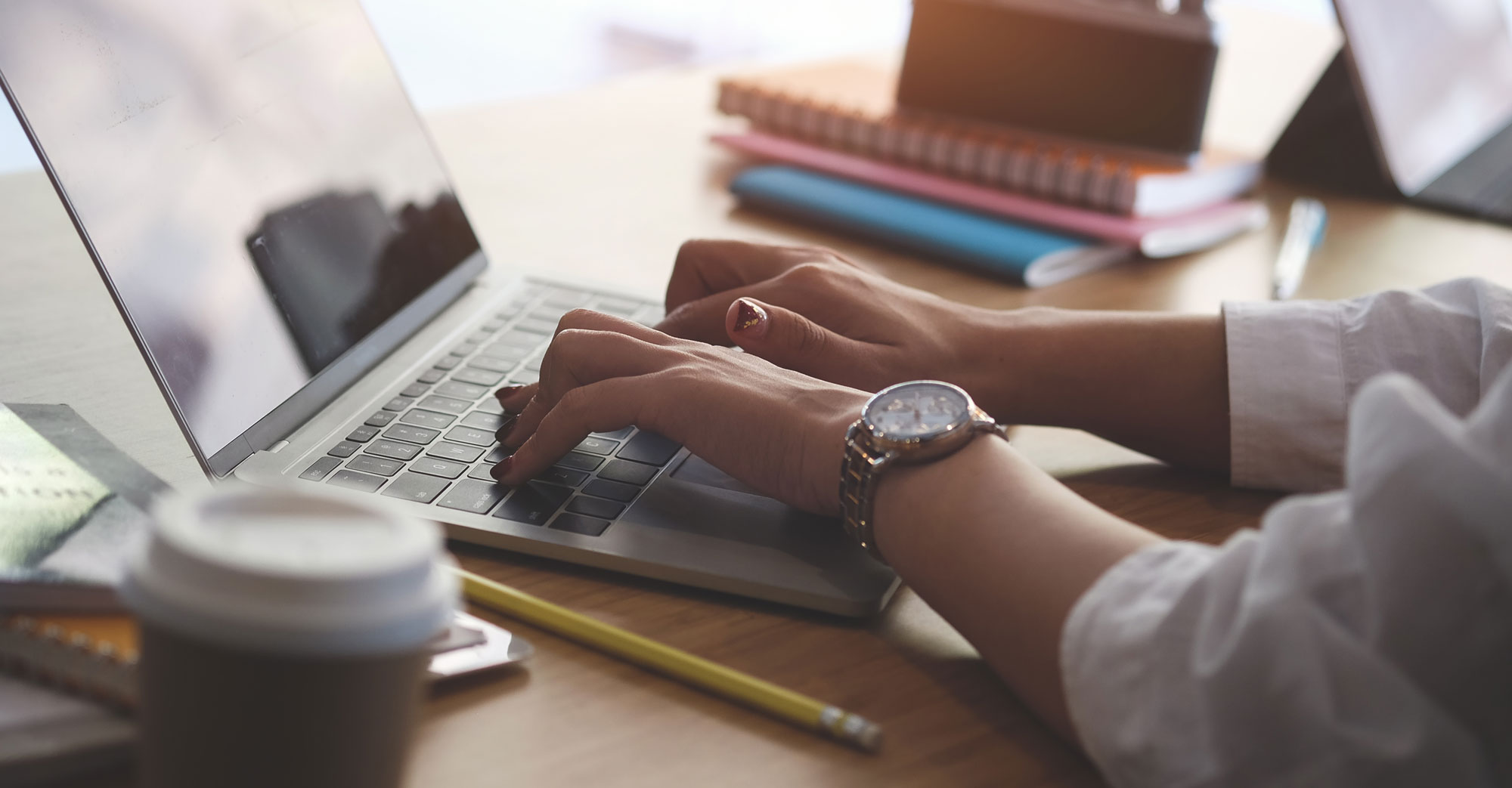 Dame sitter og jobber på mac. Foto